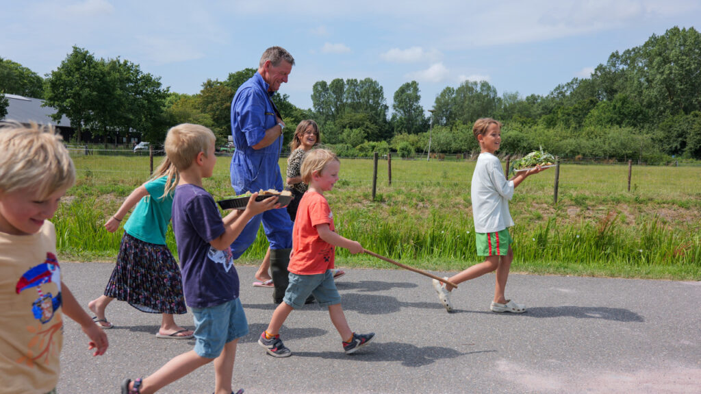 Kinderen lopen met de boer mee